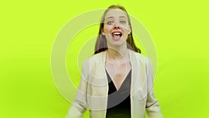 Excited overjoyed woman celebrating success in space studio on yellow