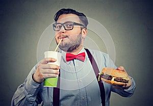 Excited overweight man eating fast food