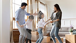 Excited parents with children celebrating moving day in new house