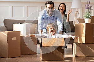 Excited parents with little son having fun on moving day