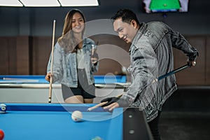 excited pool player smiling while poking the cue ball from his back