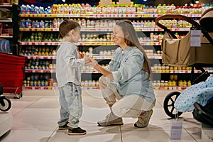 Excited pregnant mom and son fooling around in store