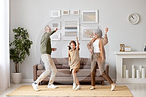 Excited preschool girl having fun with active positive grandparents