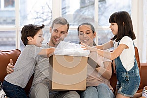 Excited kids unpack cardboard box shopping with parents online