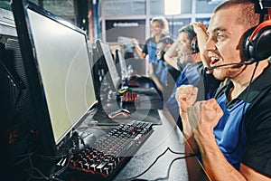 Excited professional cyber gamers, multiracial cybersport team celebrating success while playing online video game, they