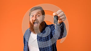 Excited Redhaired Bearded Man Shows Car Key In Excitement, Studio