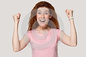 Excited redhead girl feel euphoric about success