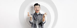 Excited romantic man showing hand hearts and smiling at camera, express love and affection, standing on white background