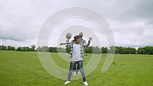 Excited school age african son celebrating touchdown during american football