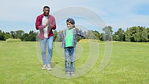 Excited school age black son celebrating touchdown during American football game