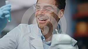 Excited scientist working microscope rejoicing research in laboratory close up.