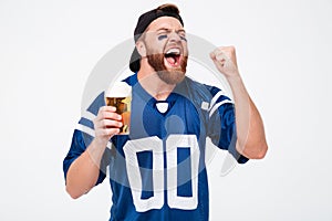 Excited screaming man fan drinking beer make winner gesture.