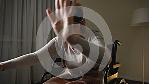 Excited senior lady in wheelchair having fun in modern virtual reality headset