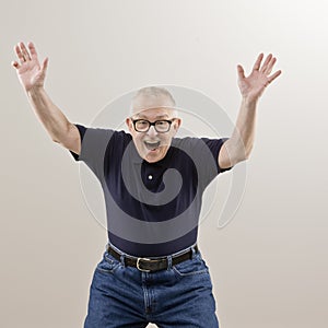 Excited senior man with arms raised