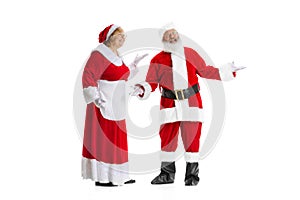 Excited senior man and beautiful woman, Santa Claus and missis Claus in traditional New Year costume isolated on white