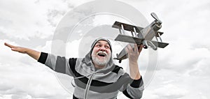 excited senior retired man. mature man at retirement. old man on sky background with toy plane