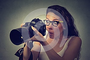 Excited shocked woman with professional DSLR camera