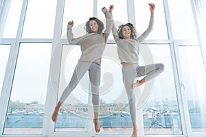 Excited sisters in casual jumping high together