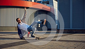 Excited skilled hipster guy making stunt on skateboard riding fast