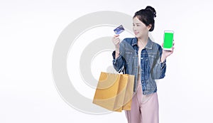 Excited smile Asian woman holding shopping bag show credit card using smartphone payment banking shopping online. Happiness lady
