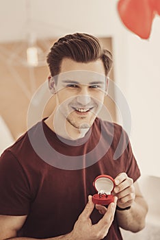 Excited smiling man showing costly engagement ring to his best friend