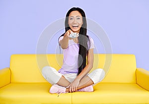 Excited smiling pretty woman watch tv changing channel with a remote control