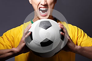 Excited sport man shouting and holding soccer