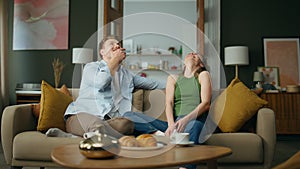 Excited spouses laughing sofa interior. Happy smiling family having fun at home