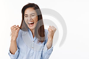 Excited successful ambitious middle-aged brunette woman in office blue blouse winning bet, fist pump celebration gesture