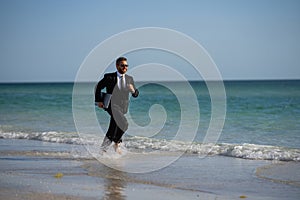 Excited summer business travel. Freelance work, online working. Summer businessman in suit run in sea water. Freelance