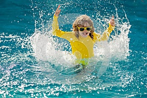 Excited summer. Child splashing in summer water pool. Kid splash in pool. Excited happy little boy jumping in pool