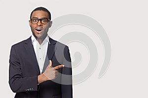 Excited surprised African American businessman pointing finger aside photo