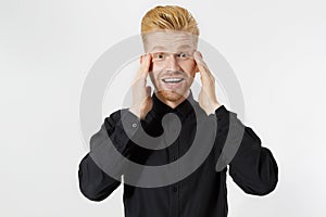 Excited surprised shock young man isolated on gray background. Happy Redhead guy with red beard in black stylish shirt. Success