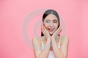 Excited and surprised smiling Asian 20s woman isolated over pink background.