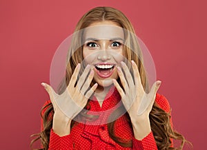 Excited surprised woman with natural makeup, curly ginger hair and manicured hand on colorful bright pink background.
