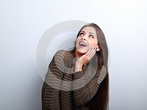 Excited surprising young woman with open mouth looking up