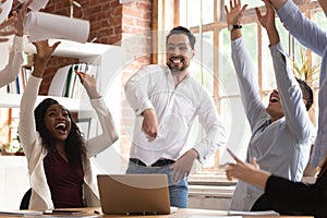 Excited team celebrating successful project accomplishment throwing papers up photo