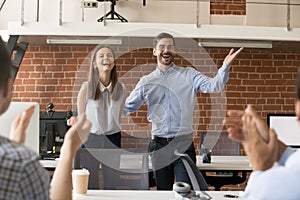 Excited team leader congratulating employee with promotion while