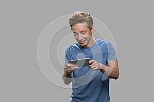 Excited teenage boy playing mobile game.