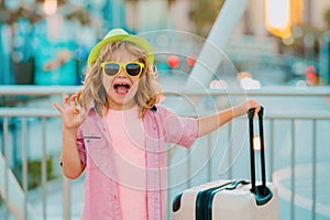 Excited tourist. Little businessman on business trip walking with his luggage on street. Kids travel and journey weekend