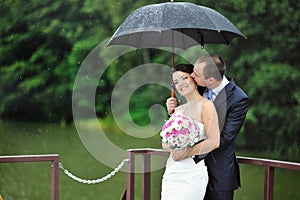 An excited wedding couple in a rainy day
