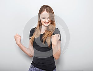 Excited winner casual woman with opened mouth. Happy young teen girl on blue background