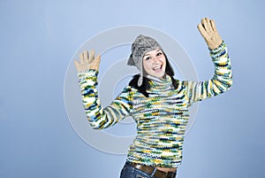 Excited winter girl with arms raised