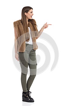 Excited Woman In Brown Fur Waistcoat Pointing Profile