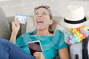 excited woman celebrating vacations sitting on sofa