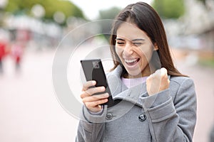 Excited woman checking content on phone