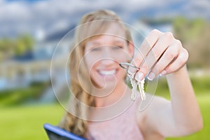 Excited Woman Holding House Keys in Front of Nice New Home.