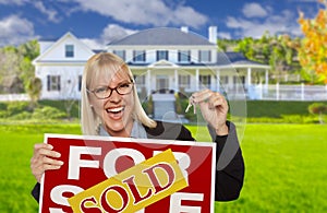 Excited Woman Holding House Keys and Sold Real Estate Sign