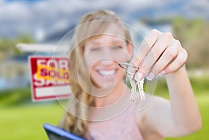 Excited Woman Holding House Keys and Sold Real Estate Sign in Fr