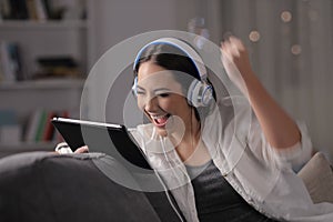 Excited woman listening and watching media on tablet